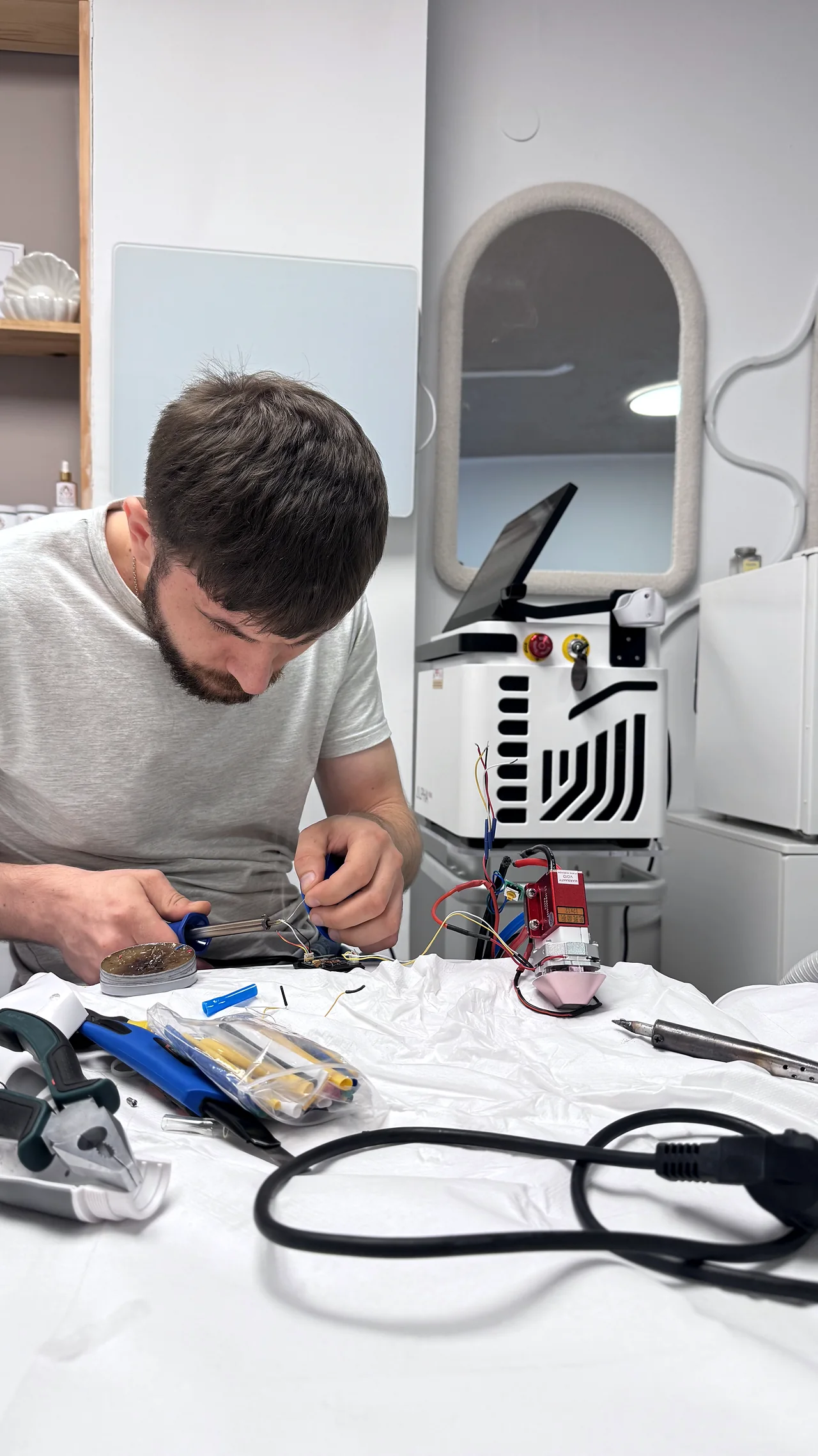 Technik pracuje przy przewodach otwartej manipuły laserowej